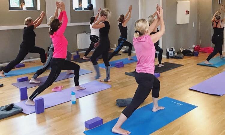 Yogatime med flere deltakere i den lyse salen